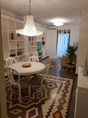 a dining room and living room with a table and chairs at Domus Valencia Apartamentos centro frente a Torres de Serrano in Valencia