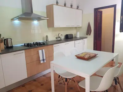 a white kitchen with a white table and chairs at Casual House Valencia in Valencia