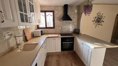 a kitchen with white cabinets and a sink at Precioso chalet en la playa de Tavernes de la Valldigna in Tavernes de Valldigna