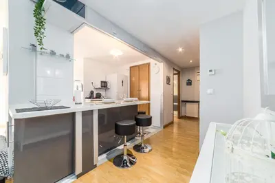 a kitchen with white cabinets and a counter with stools at Travel Habitat Palau De Les Arts in Valencia
