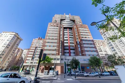 a tall building with cars parked in front of it at Travel Habitat Palau De Les Arts in Valencia
