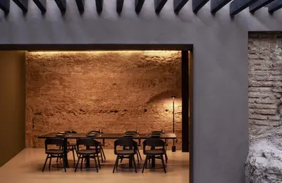 a table and chairs in a room with a brick wall at Caro Hotel in Valencia