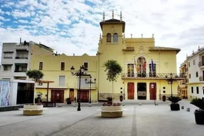 a large yellow building with a clock tower at Apartamento Cerca De Valencia in Riba-Roja De Turia