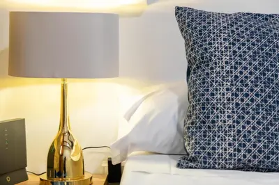 a lamp on a table next to a bed with a pillow at My Loft 4 You Temple in Valencia