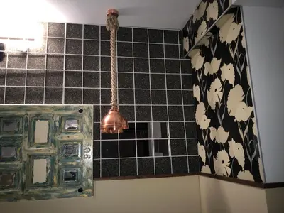 a bathroom with a black tiled wall with a light at Hostal Boutique Luna de Gavín in Cullera