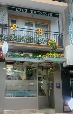 a building with a balcony with flowers on it at Hostal Boutique Luna de Gavín in Cullera