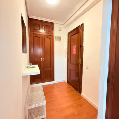 a hallway with a sink and a wooden door at Travel Habitat Mestalla in Valencia