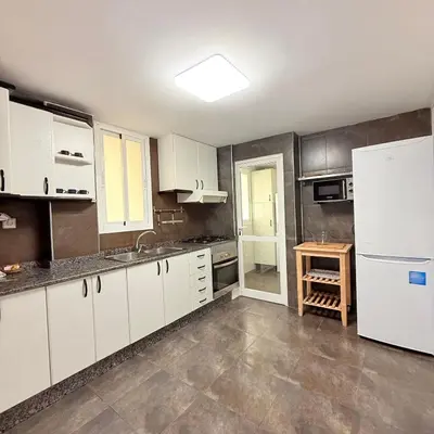 a kitchen with white cabinets and a white refrigerator at Travel Habitat Mestalla in Valencia