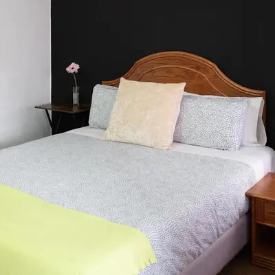 a bedroom with a white bed with a wooden headboard at Hostal Victoria in Altura