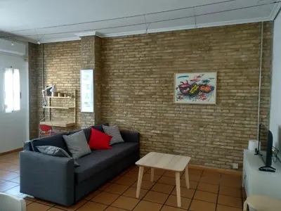 a living room with a couch and a brick wall at Apartamento con estilo in Valencia