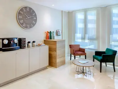 a living room with two chairs and a clock on the wall at Opera House Valencia B&B in Valencia