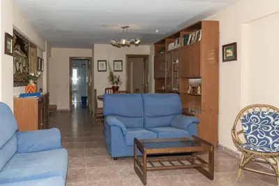 a living room with a blue couch and a table at Mar y Montaña, 2º-18 in Cullera