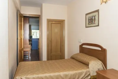 a small bedroom with a bed and a hallway at Mar y Montaña, 2º-18 in Cullera