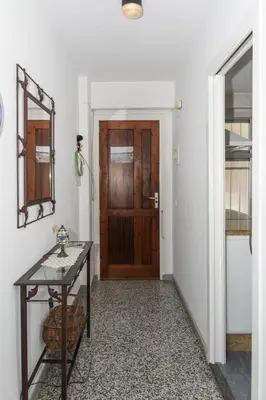 a hallway with a table and a wooden door at Estrella, 2º-10 in Cullera