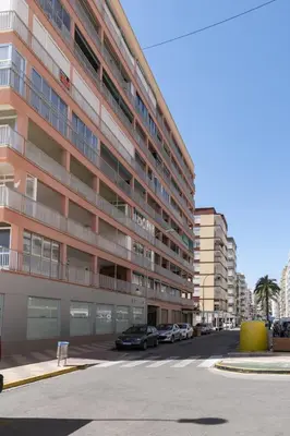 a large building with cars parked in a parking lot at Estrella, 2º-10 in Cullera