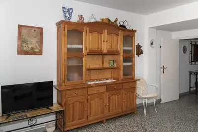 a wooden cabinet in a room with a tv at Estrella, 2º-10 in Cullera