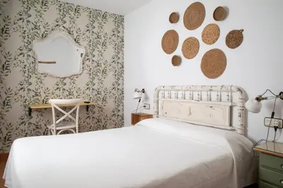 a bedroom with a white bed and a mirror at Hostal El Pozo in Chulilla