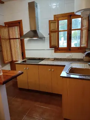 a kitchen with wooden cabinets and a sink at La Rueda Apartamentos Rurales in Chulilla