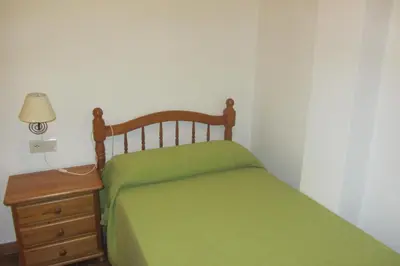a bedroom with a green bed and a night stand at La Rueda Apartamentos Rurales in Chulilla