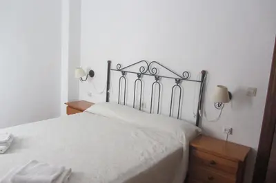 a bedroom with a bed and two night stands and two lamps at La Rueda Apartamentos Rurales in Chulilla
