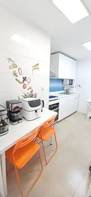 a kitchen with white cabinets and a table with orange chairs at A123 ViviendaTuristicaValencia Grandes Grupos in Valencia