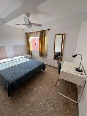 a bedroom with a bed and a desk and a mirror at Casa De La Luz in Valencia