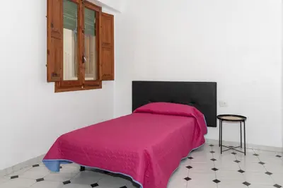 a bedroom with a bed with a pink blanket at La Ponderosa, 4º-21 in Cullera