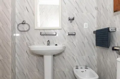 a white bathroom with a sink and a mirror at La Ponderosa, 4º-21 in Cullera