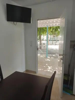 a dining room with a table and a sliding glass door at Camping Barraquetes in Sueca
