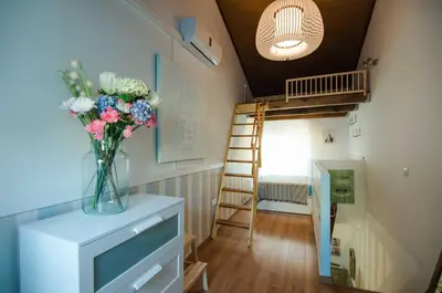 a living room with a vase of flowers on a tv at La casita azul de la playa in Valencia