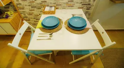 a white table with blue plates and utensils on it at La casita azul de la playa in Valencia