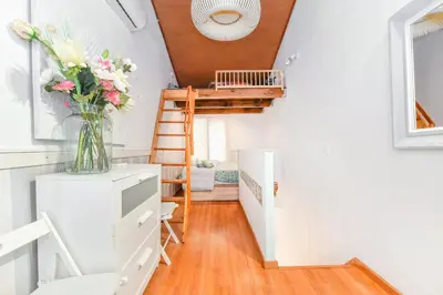 a room with a staircase and a vase of flowers at La casita azul de la playa in Valencia