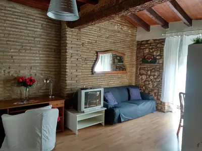 a living room with a blue couch and a tv at Centro con encanto. in Valencia