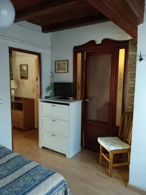 a bedroom with a bed and a dresser with a television at Centro con encanto. in Valencia