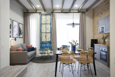 a kitchen and living room with a table and chairs at Buenos Aires Apartments in Valencia