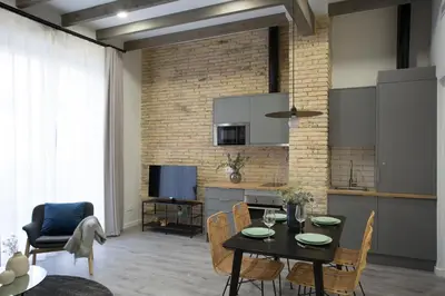a living room with a table and chairs and a kitchen at Buenos Aires Apartments in Valencia