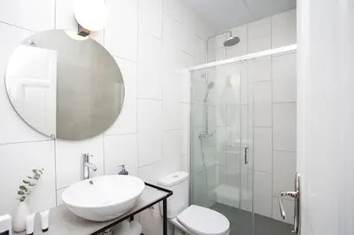 a white bathroom with a sink and a shower at Buenos Aires Apartments in Valencia