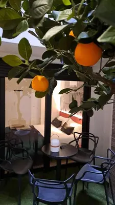 a table and chairs and a tree with oranges on it at BONNIES Suites & Spa Valencia in Valencia
