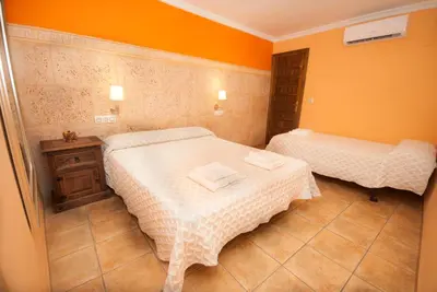 two beds in a room with orange walls at Casa La Posada de Chella in Chella