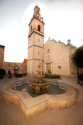 a fountain in front of a building with a clock tower at Casa La Posada de Chella in Chella