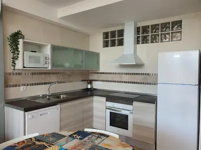 a kitchen with a sink and a white refrigerator at Balcón de las Fuentes in Navarrés