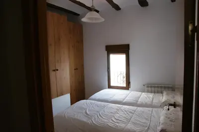 a bedroom with a white bed and a window at Casa rural El Majuelo in Portera