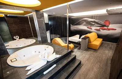 a bathroom with a tub and a bed and a mirror at Hotel Luve in San Antonio de Banageber