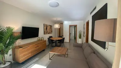 a living room with a couch and a tv and a table at Avenida Mare Nostrum 7 Patacona Beach Breakfast items in the home in Valencia