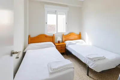 two beds in a small room with a window at Turia in Tavernes de Valldigna