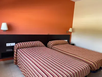 a bedroom with a bed with a striped blanket at Area de servicio El Rebollar in Requena