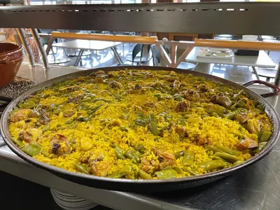 a large pizza in a pan on a table at Area de servicio El Rebollar in Requena