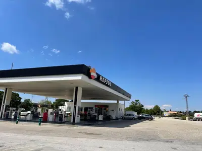 a gas station with cars parked in a parking lot at Area de servicio El Rebollar in Requena