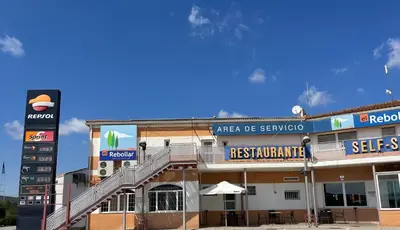 a building with a sign for a restaurant at Area de servicio El Rebollar in Requena