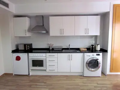 a kitchen with white cabinets and a washing machine at Your Home at Valencia, El Carme in Valencia